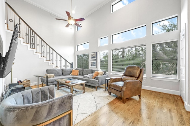 4402 Lillian St Unit 8, Houston, TX 77007 - living room featuring light wood-style flooring, crown molding, ceiling fan, stairway, and baseboards