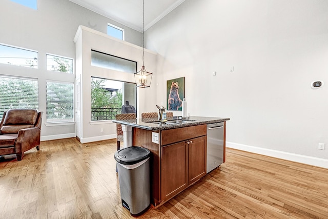 4402 Lillian St Unit 8, Houston, TX 77007 - kitchen featuring stainless steel dishwasher, crown molding, baseboards, light wood-style floors, and dark stone countertops