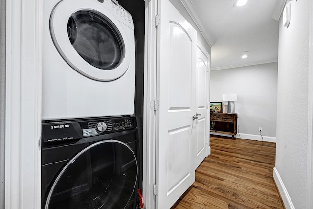 4402 Lillian St Unit 8, Houston, TX 77007 - washroom featuring stacked washing machine and dryer, baseboards, ornamental molding, wood finished floors, and recessed lighting