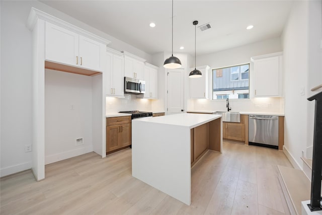 1941 Johanna Dr, Houston, TX 77055 - kitchen with appliances with stainless steel finishes, a sink, light wood finished floors, tasteful backsplash, and recessed lighting