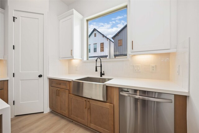 1941 Johanna Dr, Houston, TX 77055 - kitchen featuring dishwasher, a sink, light wood finished floors, backsplash, and light countertops