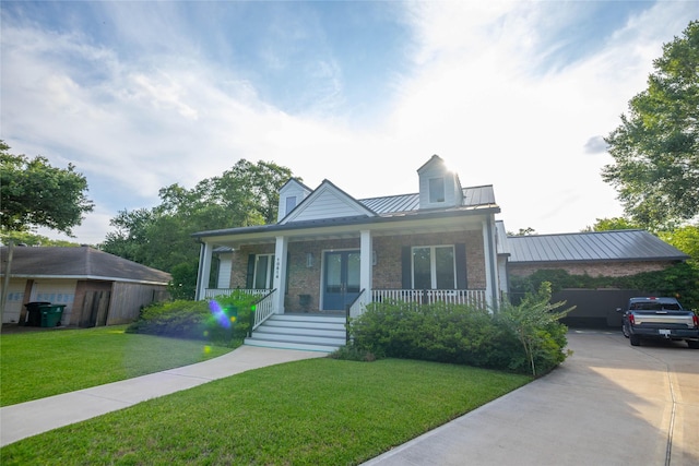 10614 Moonlight Dr, Houston, TX 77096 - view of front of house featuring a standing seam roof, a front yard, a porch, metal roof, and stone siding