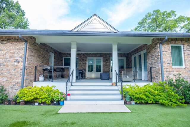 10614 Moonlight Dr, Houston, TX 77096 - property entrance featuring brick siding, a lawn, french doors, and covered porch