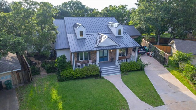 10614 Moonlight Dr, Houston, TX 77096 - view of front of home featuring a porch, a standing seam roof, concrete driveway, metal roof, and brick siding
