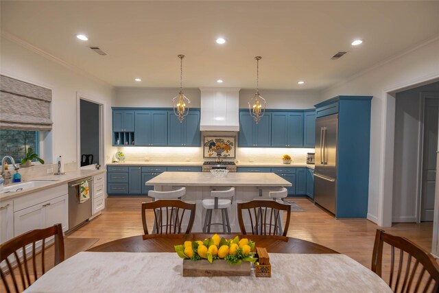10614 Moonlight Dr, Houston, TX 77096 - kitchen with blue cabinetry, a sink, stainless steel appliances, light countertops, and tasteful backsplash