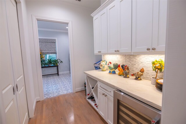 10614 Moonlight Dr, Houston, TX 77096 - bar featuring beverage cooler, tasteful backsplash, crown molding, light wood finished floors, and baseboards