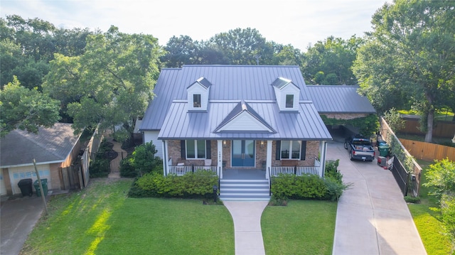 10614 Moonlight Dr, Houston, TX 77096 - view of front of property featuring brick siding, driveway, covered porch, a standing seam roof, and a front lawn