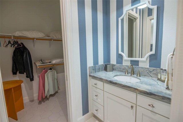 10614 Moonlight Dr, Houston, TX 77096 - bathroom featuring vanity, tile patterned floors, a spacious closet, and baseboards