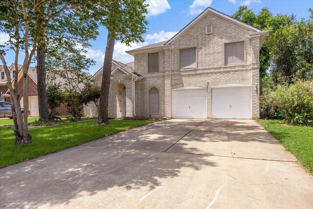 21326 Wildcroft Dr, Katy, TX 77449 - view of front of property featuring brick siding, a garage, driveway, and a front lawn