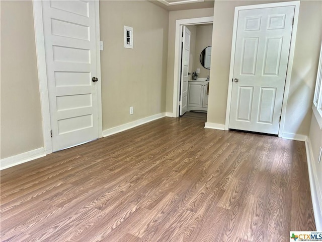 515 Mitchell Ave, Seguin, TX 78155 - unfurnished bedroom with wood finished floors, baseboards, and ensuite bathroom