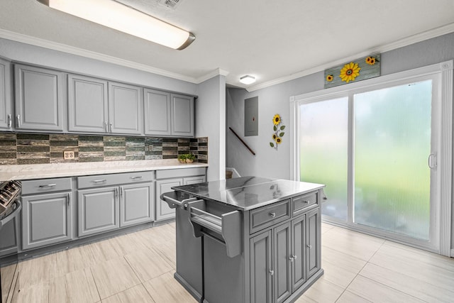 20 Clearview St, Point Blank, TX 77364 - kitchen with gray cabinetry, tasteful backsplash, ornamental molding, light tile patterned floors, and stainless steel stove