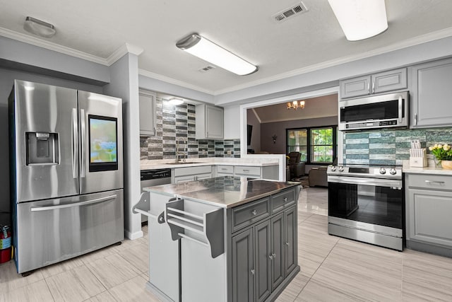 20 Clearview St, Point Blank, TX 77364 - kitchen featuring appliances with stainless steel finishes, gray cabinetry, a sink, tasteful backsplash, and ornamental molding