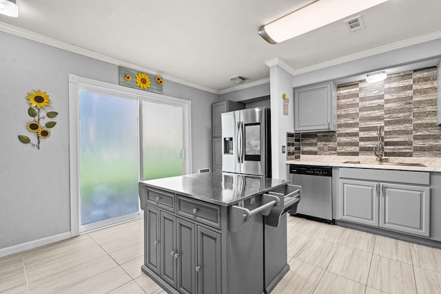 20 Clearview St, Point Blank, TX 77364 - kitchen with appliances with stainless steel finishes, gray cabinetry, a sink, tasteful backsplash, and crown molding