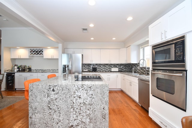 2307 Briar Branch Dr, Houston, TX 77042 - kitchen featuring stainless steel appliances, crown molding, a sink, a center island, and beverage cooler