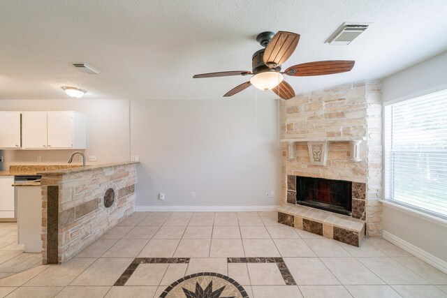 423 N Vista Dr, Houston, TX 77073 - unfurnished living room featuring a fireplace, a ceiling fan, light tile patterned floors, a sink, and baseboards