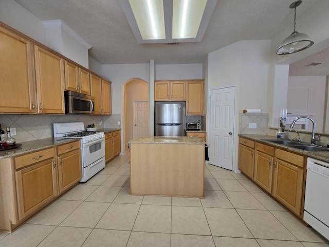 17427 N Riata Lake Dr, Cypress, TX 77433 - kitchen with appliances with stainless steel finishes, a sink, decorative backsplash, and arched walkways