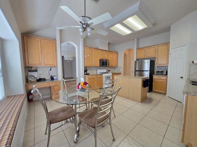 17427 N Riata Lake Dr, Cypress, TX 77433 - dining area with arched walkways, a ceiling fan, light tile patterned floors, vaulted ceiling, and a chandelier