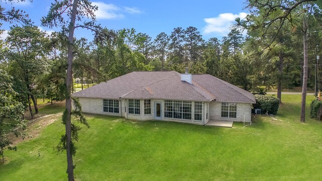 627 Shoreline Dr, Brookeland, TX 75931 - rear view of house with a lawn, a chimney, a patio area, and view of scattered trees