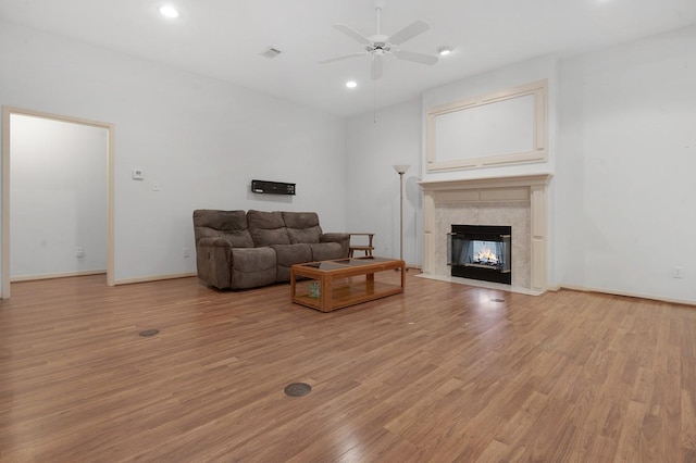 627 Shoreline Dr, Brookeland, TX 75931 - living area with light wood-style flooring, a ceiling fan, a high end fireplace, recessed lighting, and baseboards