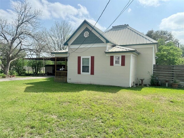 706 W St, Yoakum, TX 77995 - view of side of home featuring metal roof and a carport