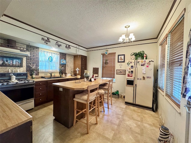 706 W St, Yoakum, TX 77995 - kitchen featuring butcher block counters, white refrigerator with ice dispenser, range with gas cooktop, a textured ceiling, and dark brown cabinetry