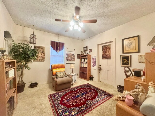 706 W St, Yoakum, TX 77995 - living area featuring carpet floors, ceiling fan, and a textured ceiling