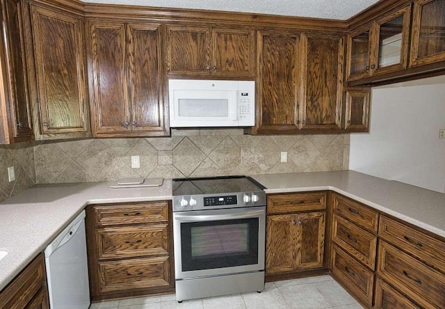 208 Roark Ln, Jones Creek, TX 77541 - kitchen featuring white appliances, light countertops, backsplash, and light tile patterned flooring