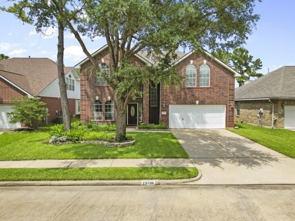 23706 River Place Dr, Katy, TX 77494 - traditional home with brick siding, an attached garage, driveway, and a front lawn
