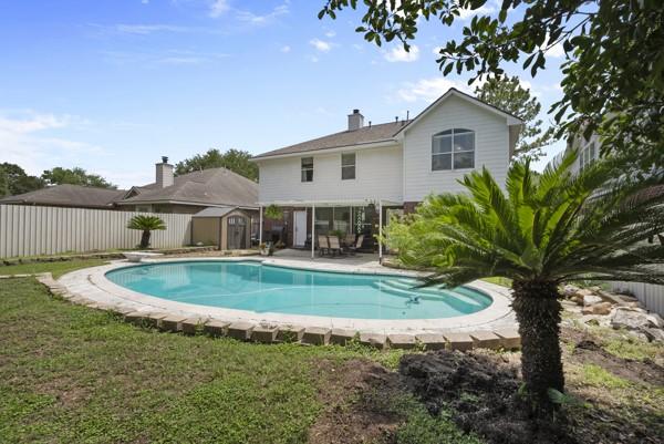 23706 River Place Dr, Katy, TX 77494 - rear view of house featuring a fenced backyard, a chimney, and a patio area
