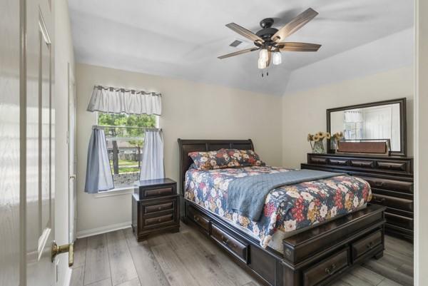 23706 River Place Dr, Katy, TX 77494 - bedroom featuring wood finished floors, baseboards, ceiling fan, and lofted ceiling