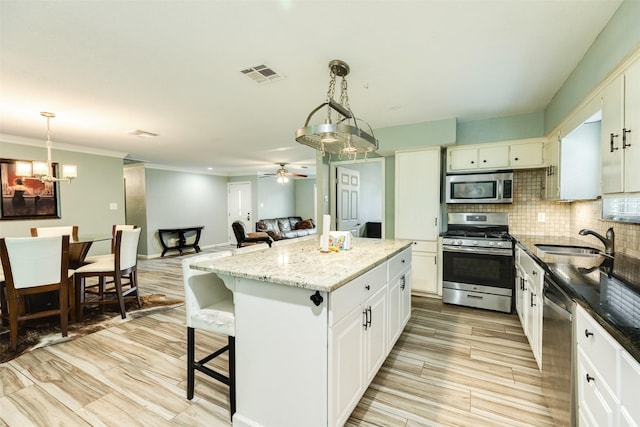 6915 Oak Bend Dr, Alvin, TX 77511 - kitchen with appliances with stainless steel finishes, a sink, a center island, tasteful backsplash, and pendant lighting