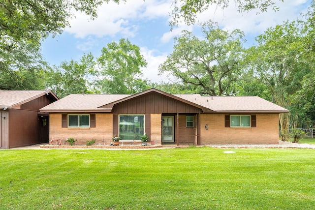 6915 Oak Bend Dr, Alvin, TX 77511 - ranch-style house with brick siding, a front yard, and a shingled roof