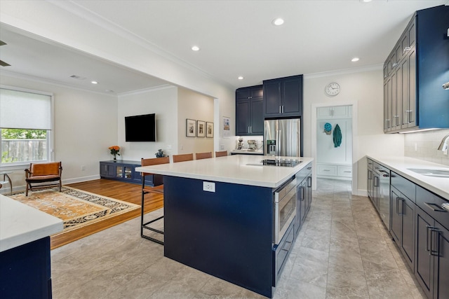 523 W 15th St, Houston, TX 77008 - kitchen with appliances with stainless steel finishes, ornamental molding, a breakfast bar, light countertops, and a center island