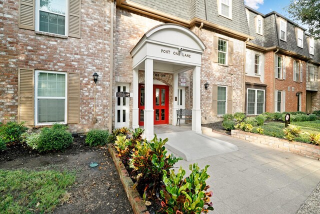 355 N Post Oak Ln Unit 743, Houston, TX 77024 - doorway to property featuring mansard roof, french doors, brick siding, and a shingled roof