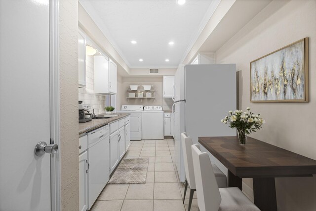 355 N Post Oak Ln Unit 743, Houston, TX 77024 - kitchen with white appliances, a sink, white cabinetry, light tile patterned floors, and ornamental molding