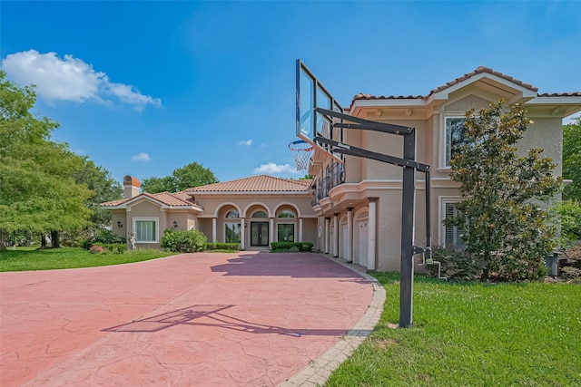 8522 Haven Trl, Tomball, TX 77375 - mediterranean / spanish house featuring stucco siding, driveway, a tiled roof, and a front lawn