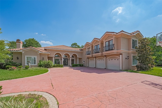 8522 Haven Trl, Tomball, TX 77375 - mediterranean / spanish house with a balcony, stucco siding, a tile roof, and a garage