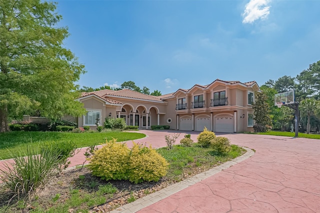 8522 Haven Trl, Tomball, TX 77375 - mediterranean / spanish home with curved driveway, an attached garage, stucco siding, a balcony, and a tiled roof