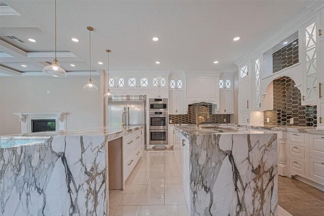 8522 Haven Trl, Tomball, TX 77375 - kitchen with a large island, ornamental molding, a fireplace, stainless steel appliances, and light stone counters
