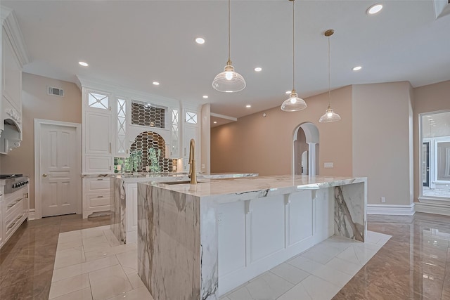 8522 Haven Trl, Tomball, TX 77375 - kitchen with a large island, light stone countertops, white cabinetry, light marble finish flooring, and recessed lighting