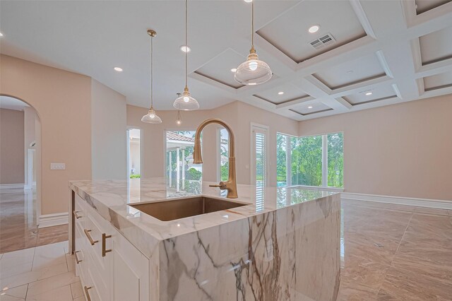8522 Haven Trl, Tomball, TX 77375 - kitchen with a sink, arched walkways, healthy amount of natural light, coffered ceiling, and light stone countertops