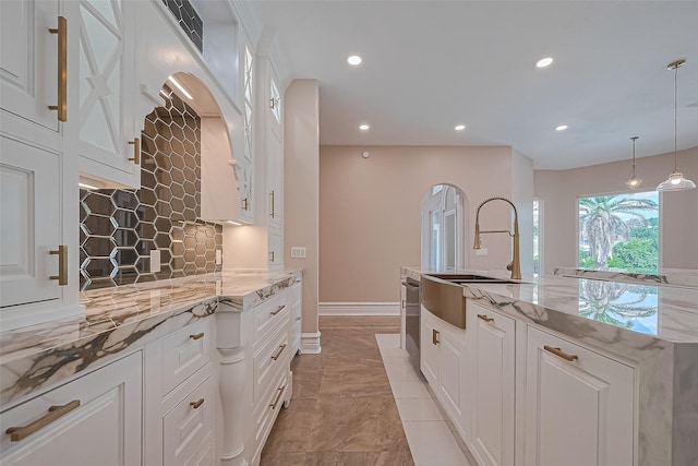8522 Haven Trl, Tomball, TX 77375 - kitchen with a sink, backsplash, light marble finish flooring, white cabinets, and recessed lighting