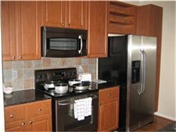 1711 Old Spanish Trl Unit 243, Houston, TX 77054 - kitchen with black appliances, tasteful backsplash, dark countertops, and open shelves