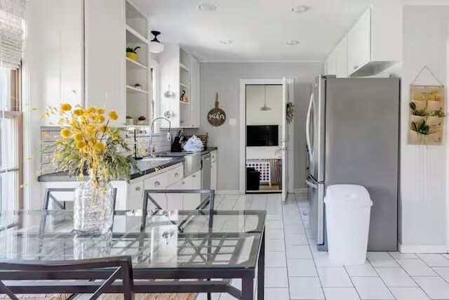 701 Gilchrist, College Station, TX 77840 - kitchen with freestanding refrigerator, white cabinets, open shelves, light tile patterned flooring, and dark countertops