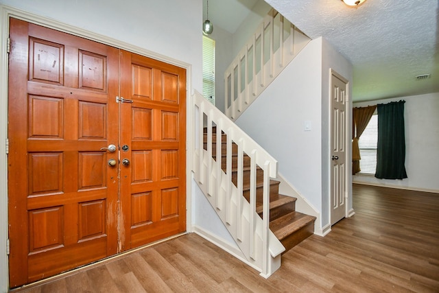 16323 Elmwood Point Ln, Sugar Land, TX 77498 - entryway with wood finished floors, stairway, baseboards, and a textured ceiling
