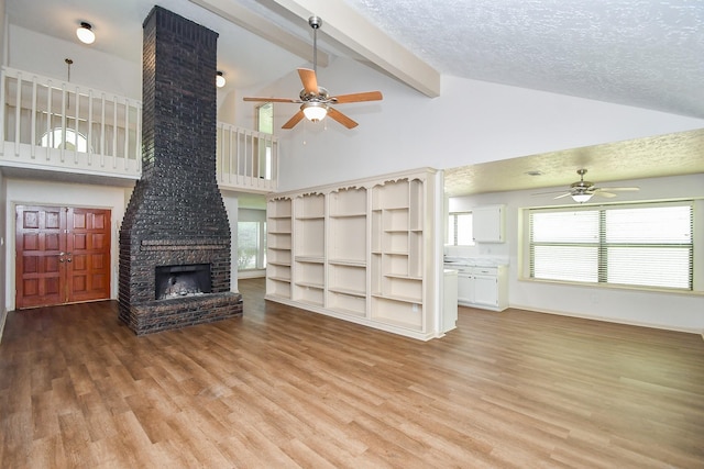 16323 Elmwood Point Ln, Sugar Land, TX 77498 - unfurnished living room featuring ceiling fan, light wood-style floors, beamed ceiling, high vaulted ceiling, and a textured ceiling