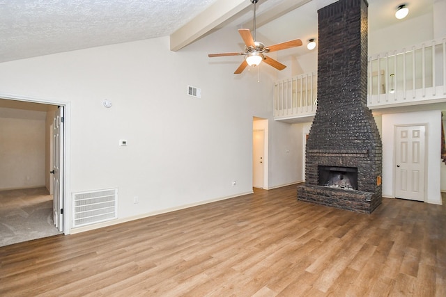 16323 Elmwood Point Ln, Sugar Land, TX 77498 - unfurnished living room featuring ceiling fan, high vaulted ceiling, wood finished floors, beamed ceiling, and a fireplace