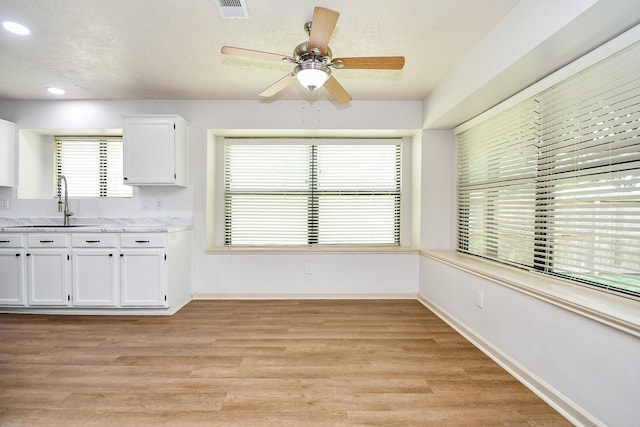 16323 Elmwood Point Ln, Sugar Land, TX 77498 - kitchen with a sink, white cabinets, light wood-style flooring, a ceiling fan, and recessed lighting