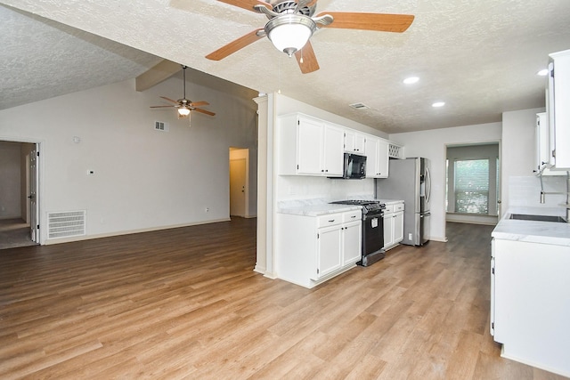 16323 Elmwood Point Ln, Sugar Land, TX 77498 - kitchen featuring appliances with stainless steel finishes, a textured ceiling, ceiling fan, light wood-type flooring, and white cabinetry