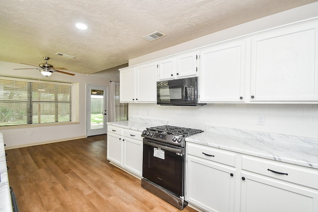 16323 Elmwood Point Ln, Sugar Land, TX 77498 - kitchen featuring black microwave, stainless steel gas range oven, tasteful backsplash, a ceiling fan, and a textured ceiling